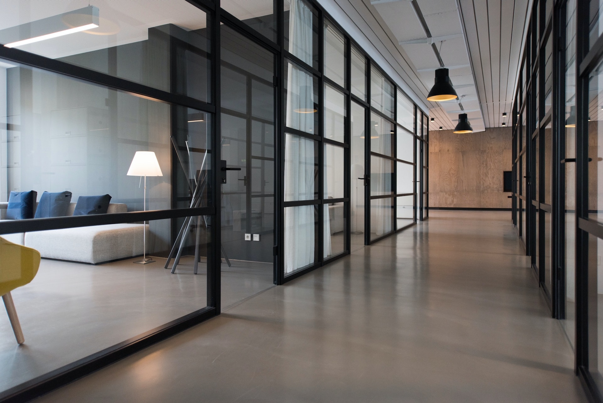 Modernes Büro mit Glaswänden, minimalistischer Einrichtung und industriellem Design, perfekt für eine zeitgemäße Arbeitsumgebung.